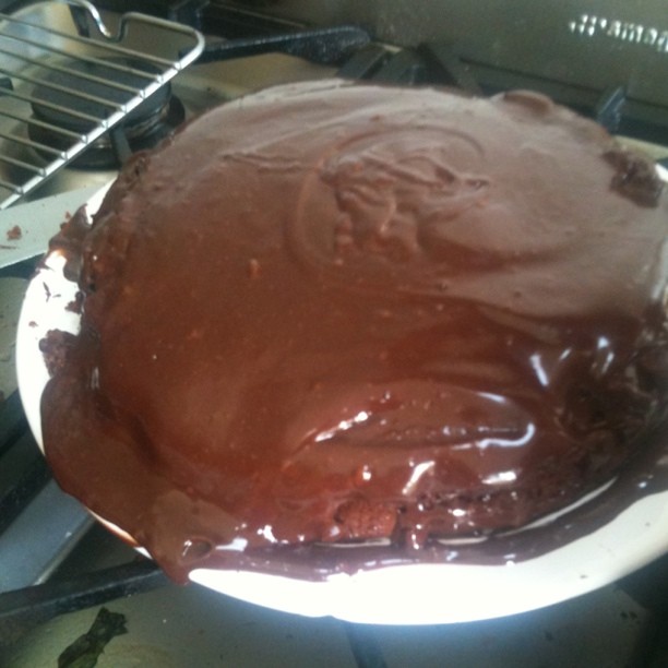 a large chocolate cake is cooking on a stove
