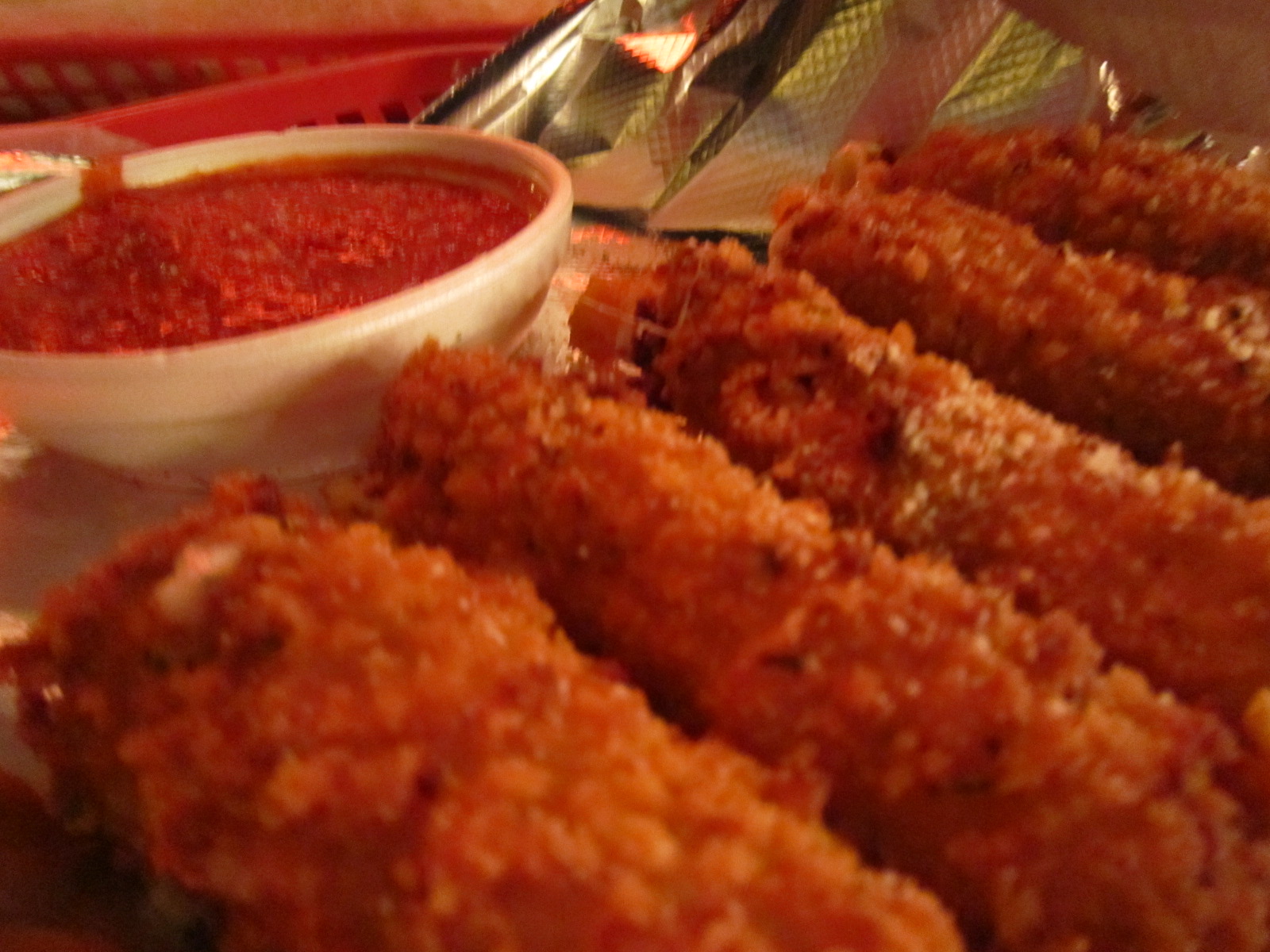 a plate of fried meat sticks next to some dipping sauce