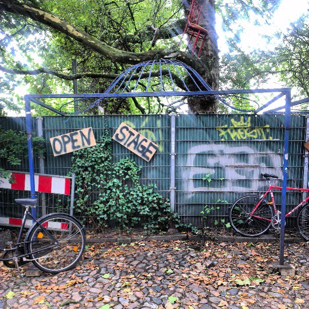 bicycles parked next to a fence with graffiti