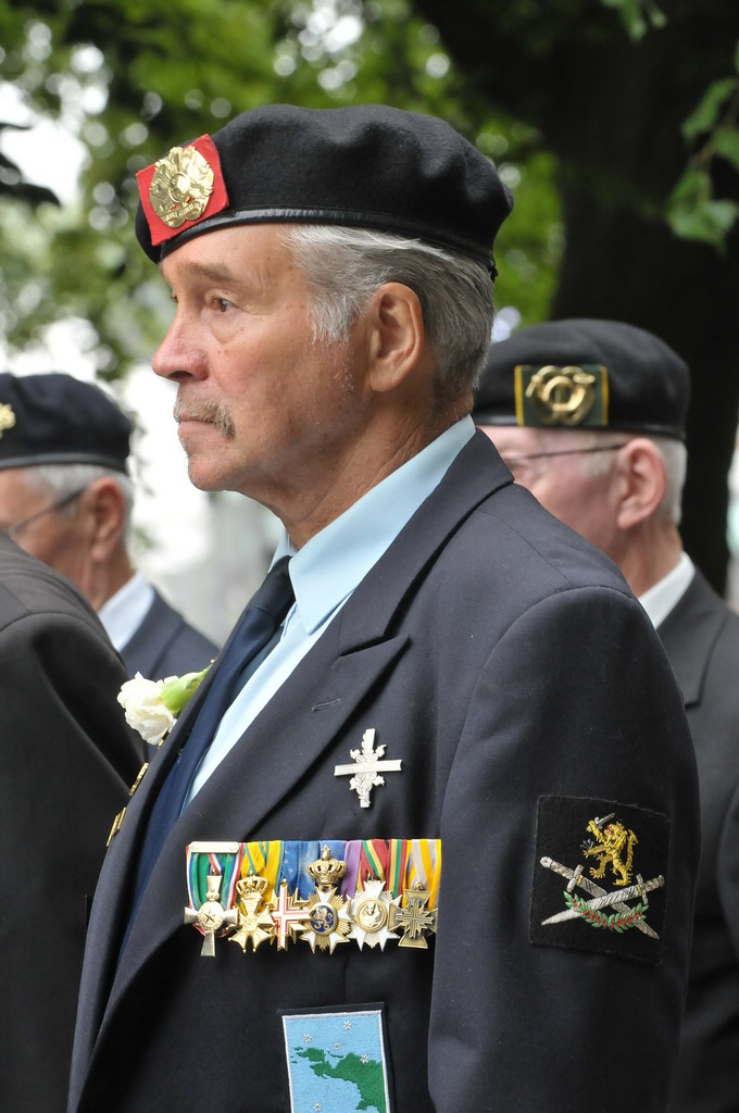 an older man in a military uniform looks off into the distance