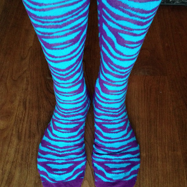 the legs of a person wearing blue and purple socks