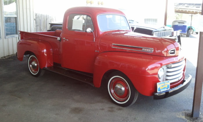 a vintage red truck parked by some buildings