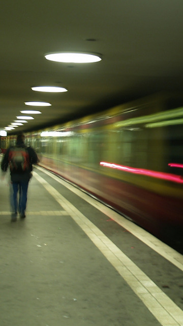 some people walking on the platform of a subway station