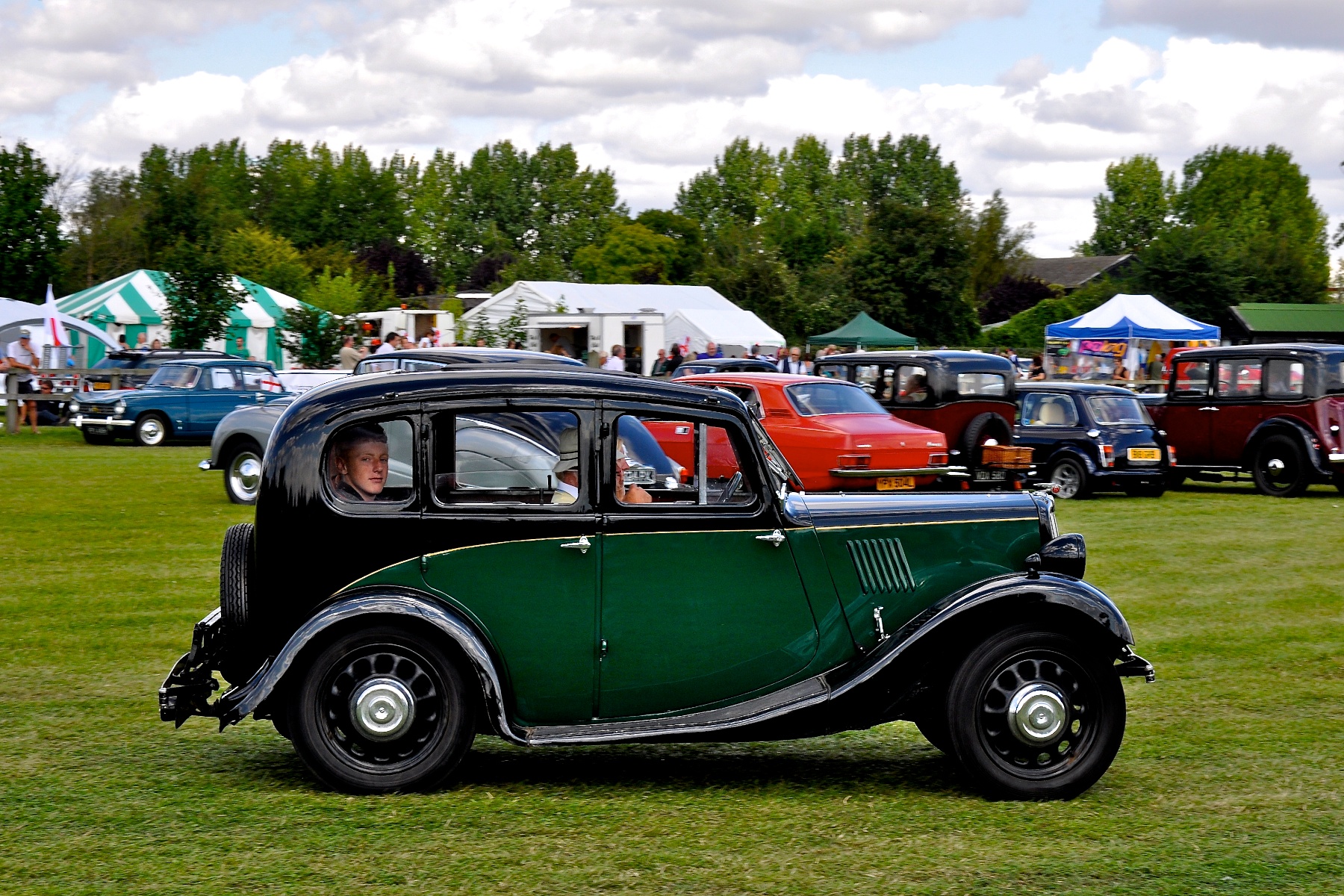 the classic car is parked in the field