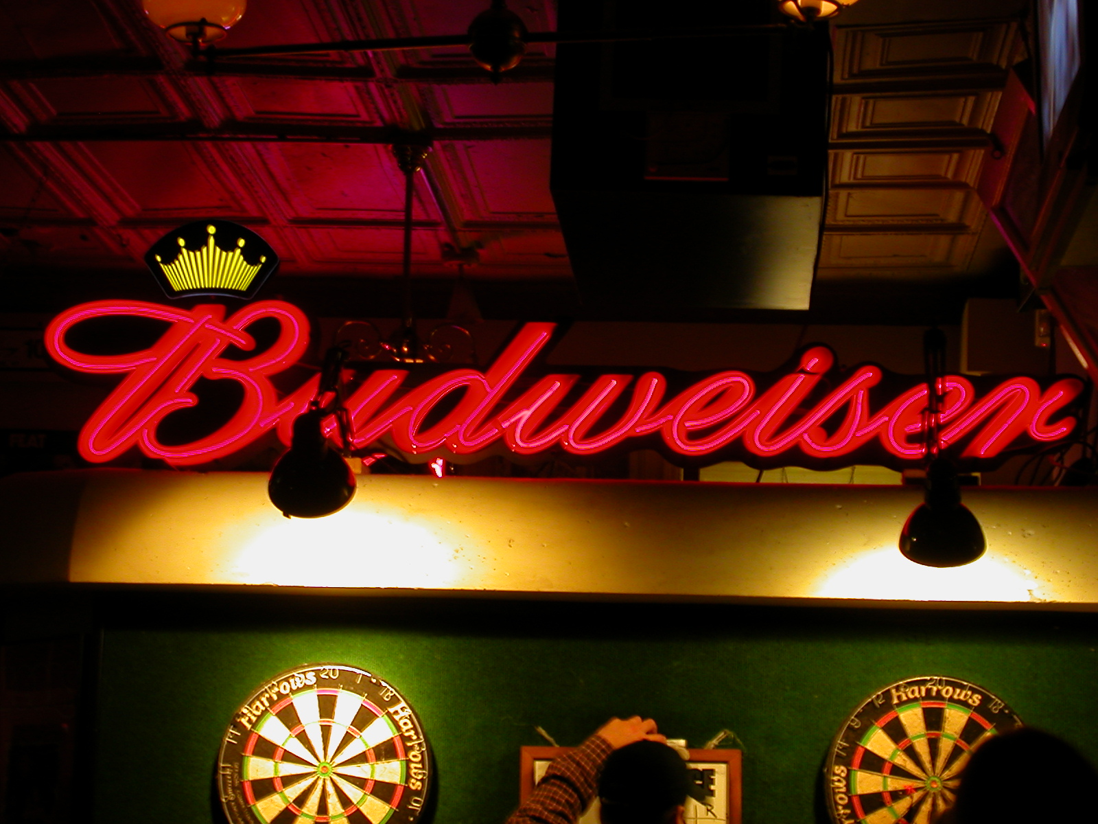 neon sign above darts and darts in a dark room