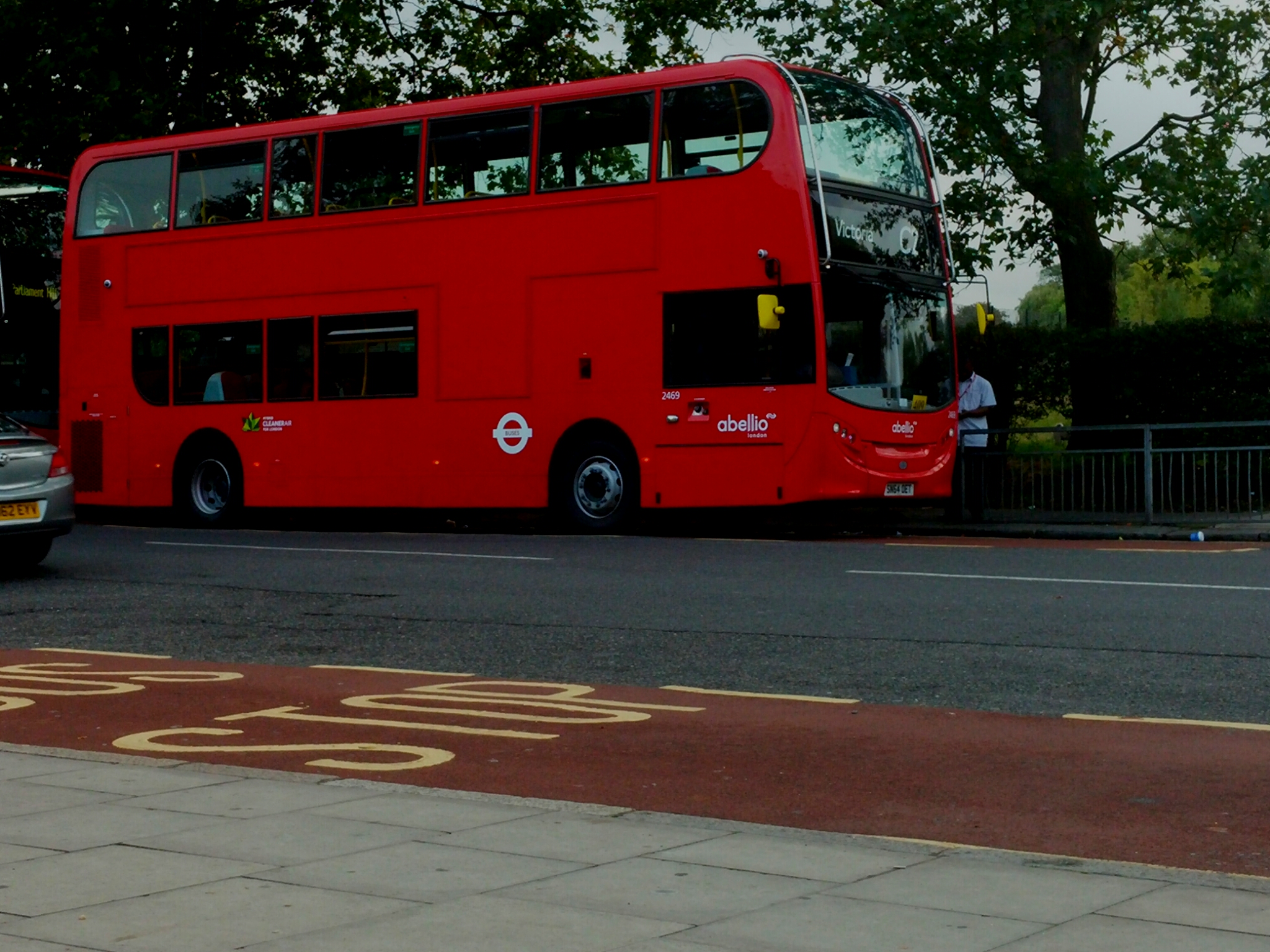 two red double decker busses one is a ford mustang