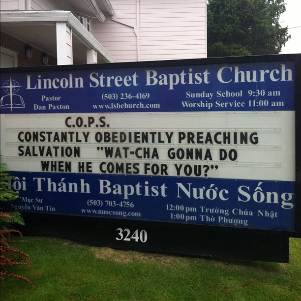 the back side of the sign is in front of a church