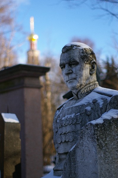 a stone statue is in the snow near a light tower