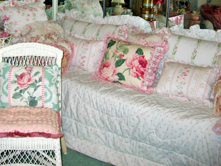 there are pink roses sitting on pillows on the couch