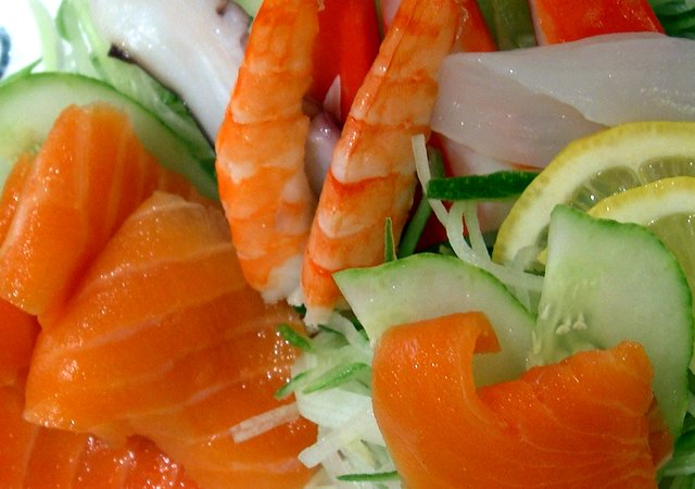 a close up image of a salad containing salmon, cucumber and lettuce