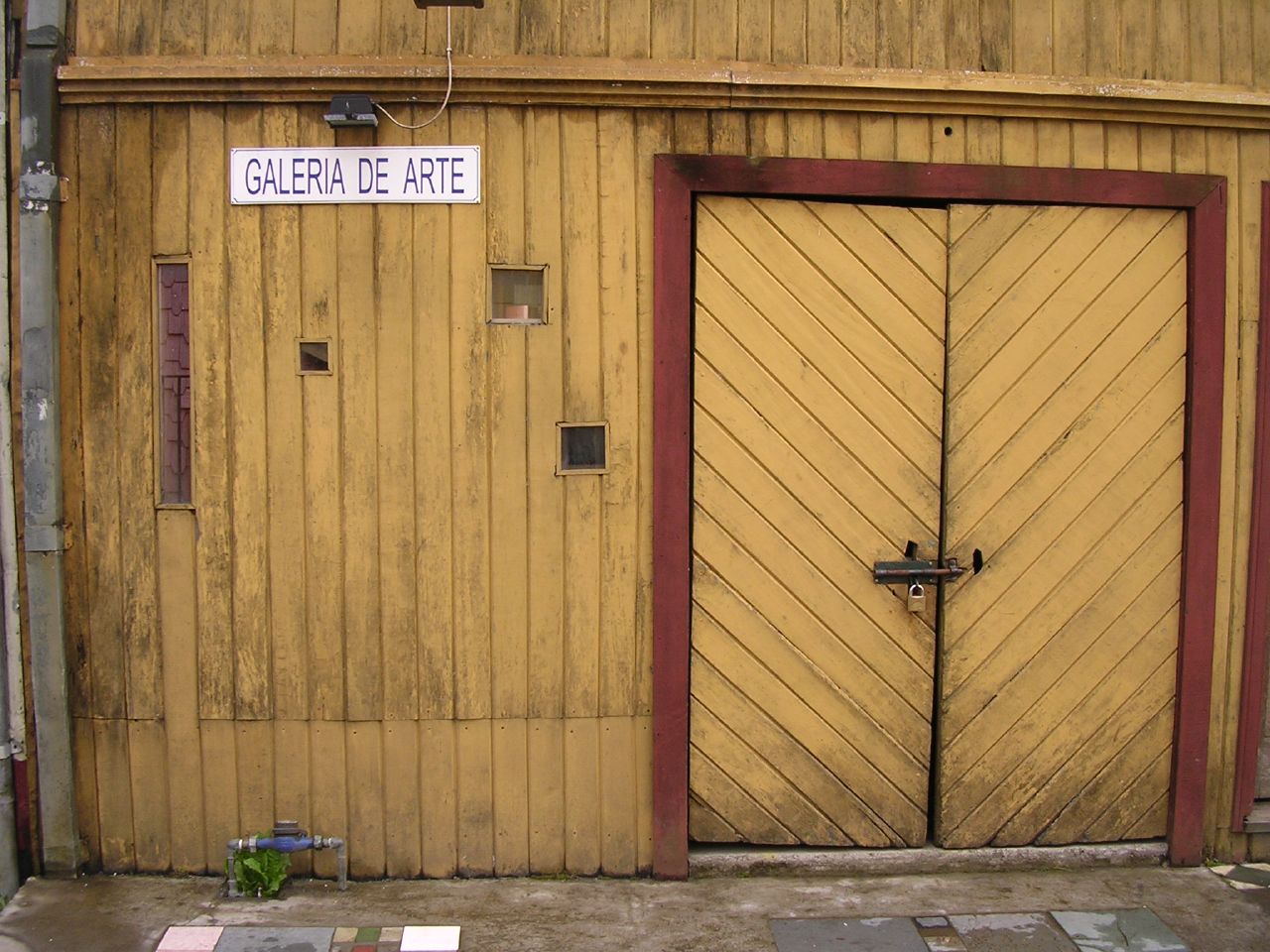 an open brown door sitting next to a wooden building