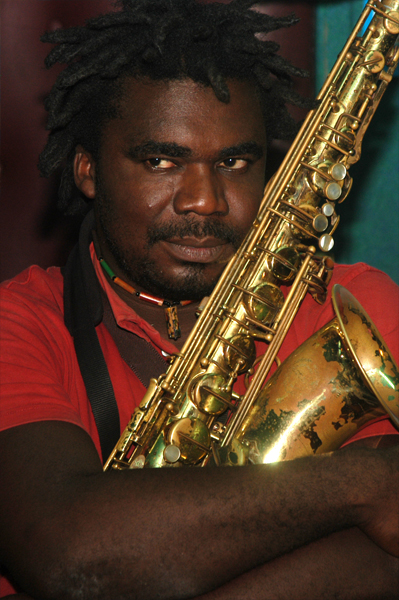 a man with dreadlocks plays a saxophone