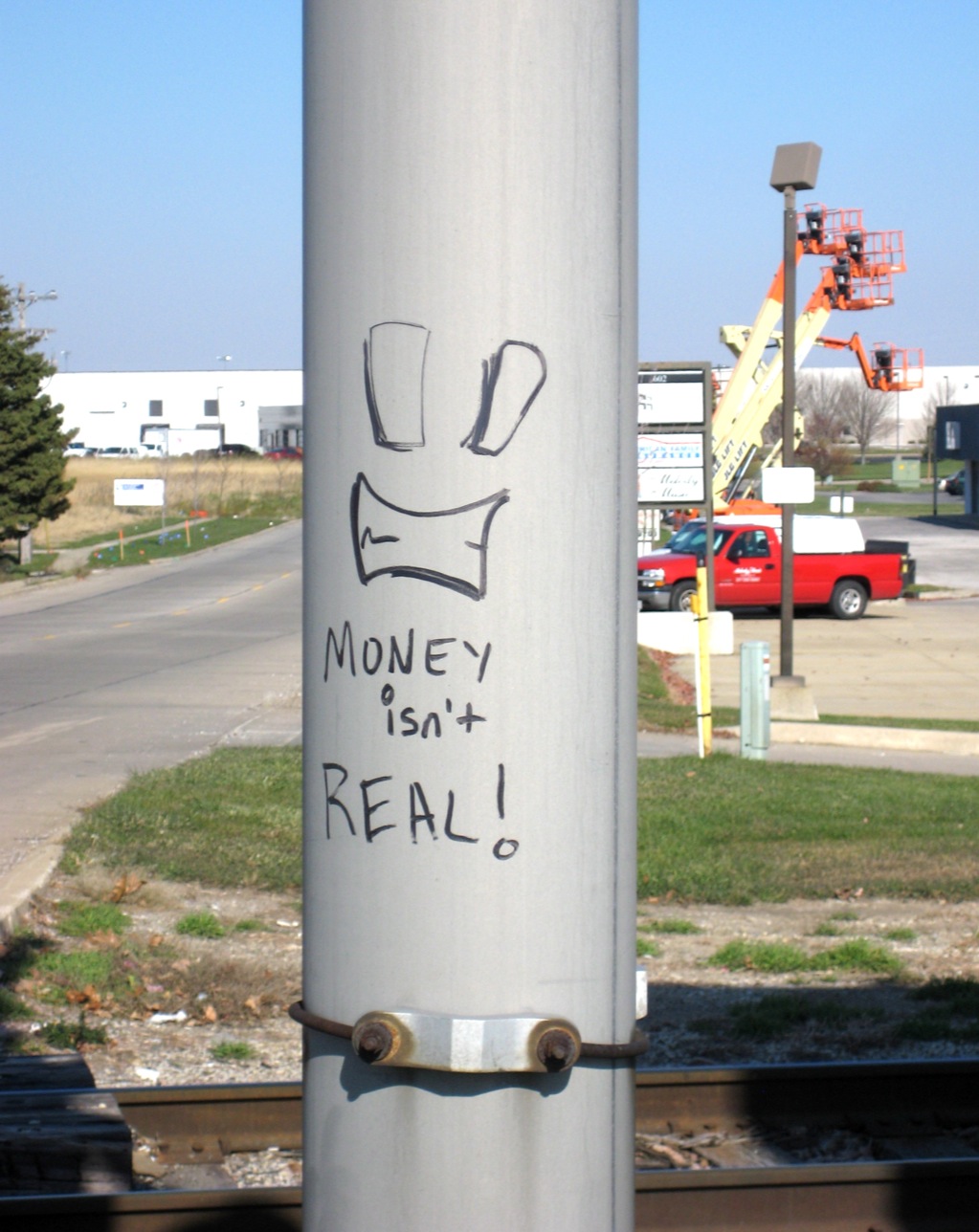 graffiti on a pole with a house in the background