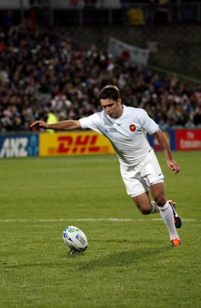 a man in white is on the field with a soccer ball