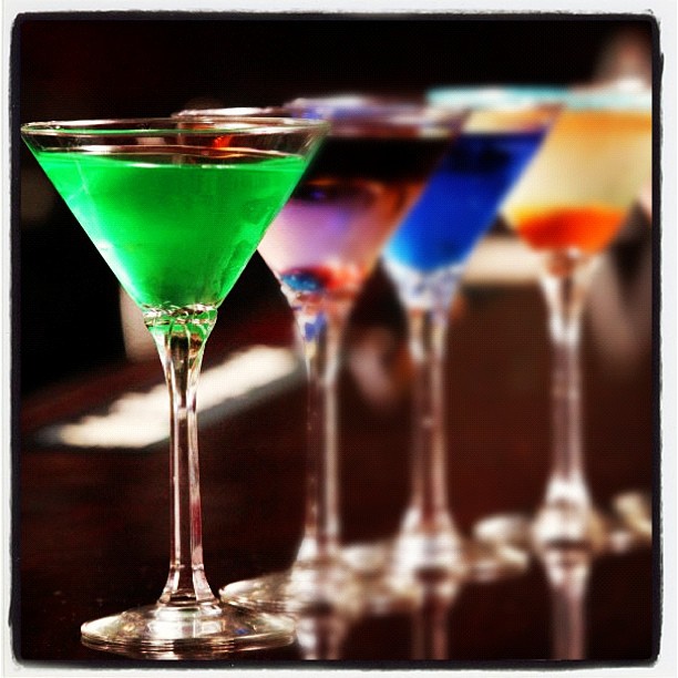 six martinis are on a bar lined up