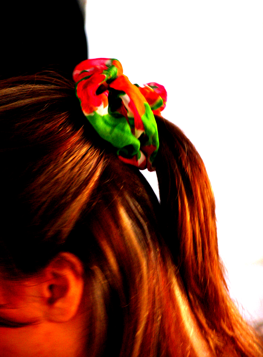 a woman with long hair with a colorful piece of cloth tied to her head