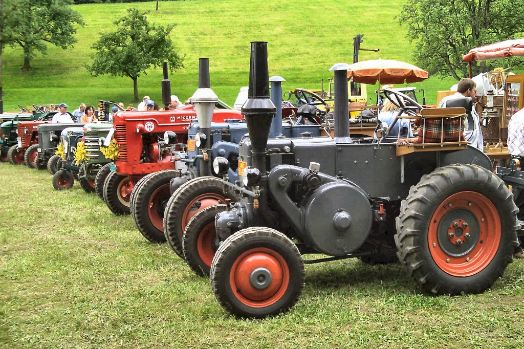old tractors and tractors lined up in rows for sale