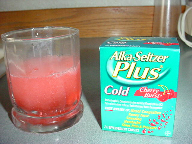 a box of alaska seltzer plus sits next to a drink glass
