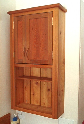 a wooden cabinet over a toilet in a bathroom