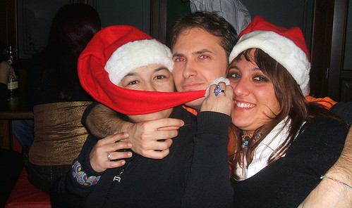 three people hug while smiling and covering their faces