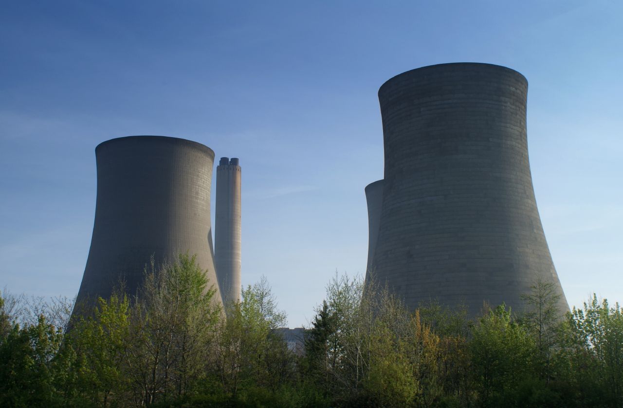 two large cooling towers towering over a forest