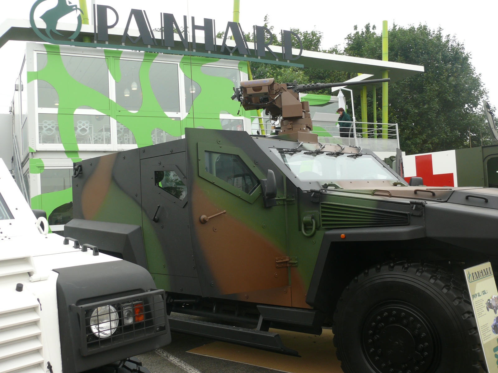 a large army vehicle parked by a green wall