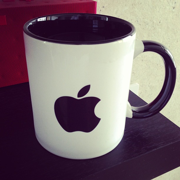 an apple mug is sitting on a table