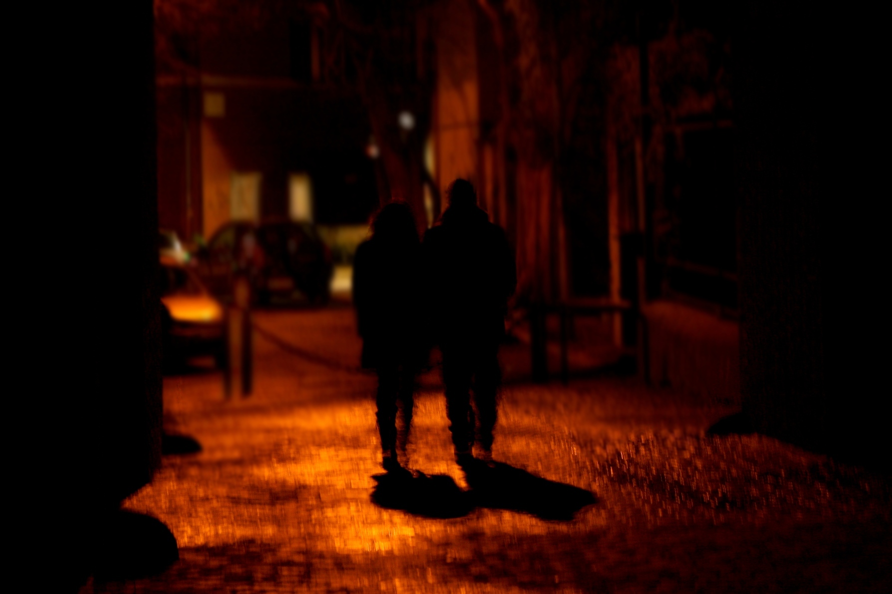 people walking on the sidewalk at night or in the street