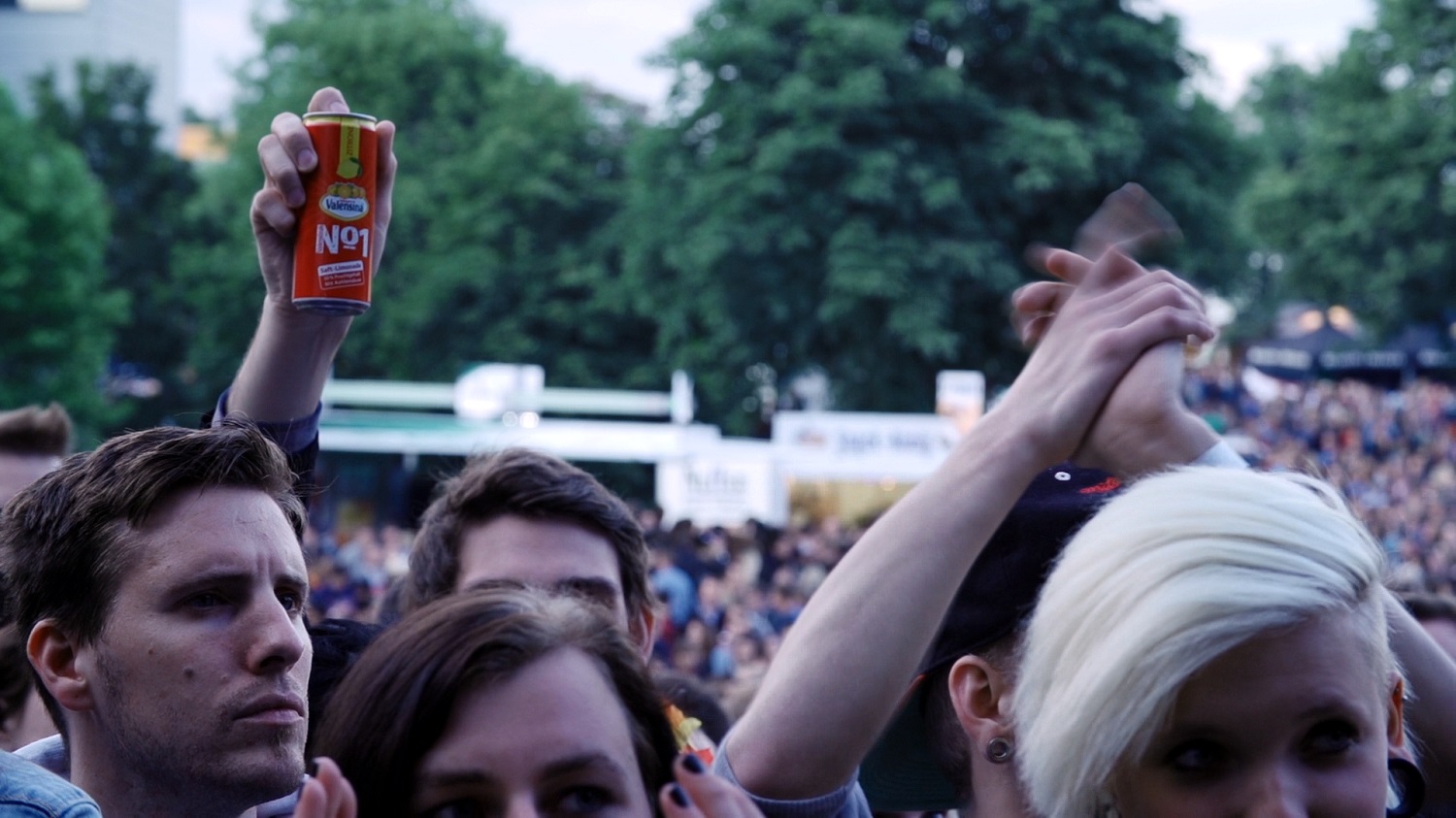 several people stand together with drinks in their hand