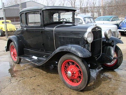 an old style truck parked on a rainy day