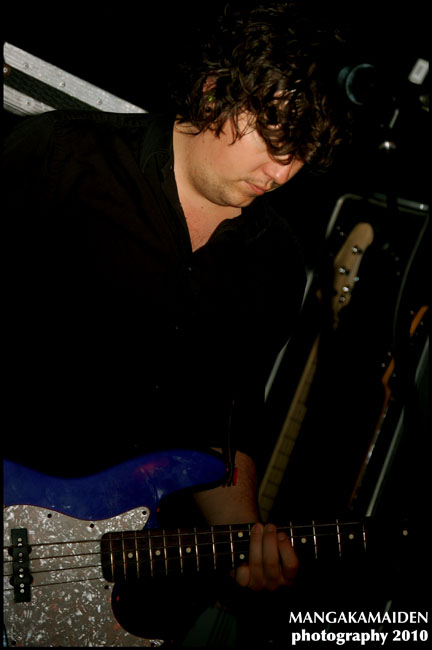 a man playing the guitar at night on stage