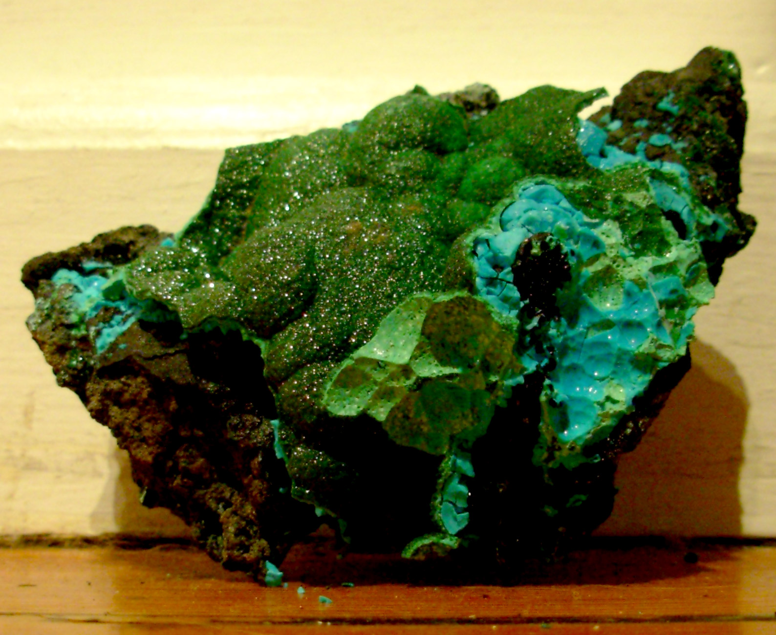 a green piece of rock that is near the wall