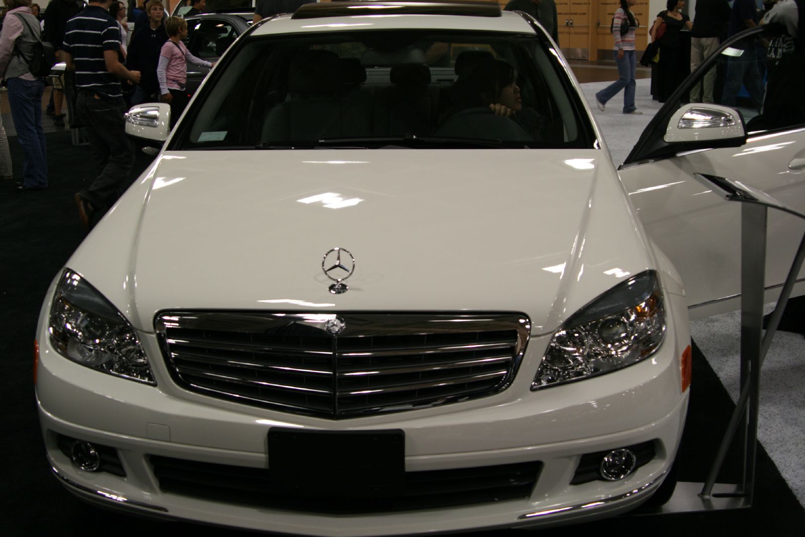 a mercedes car is parked in front of other people