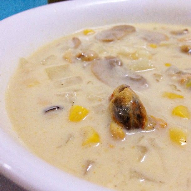 a bowl filled with soup topped with lots of vegetables