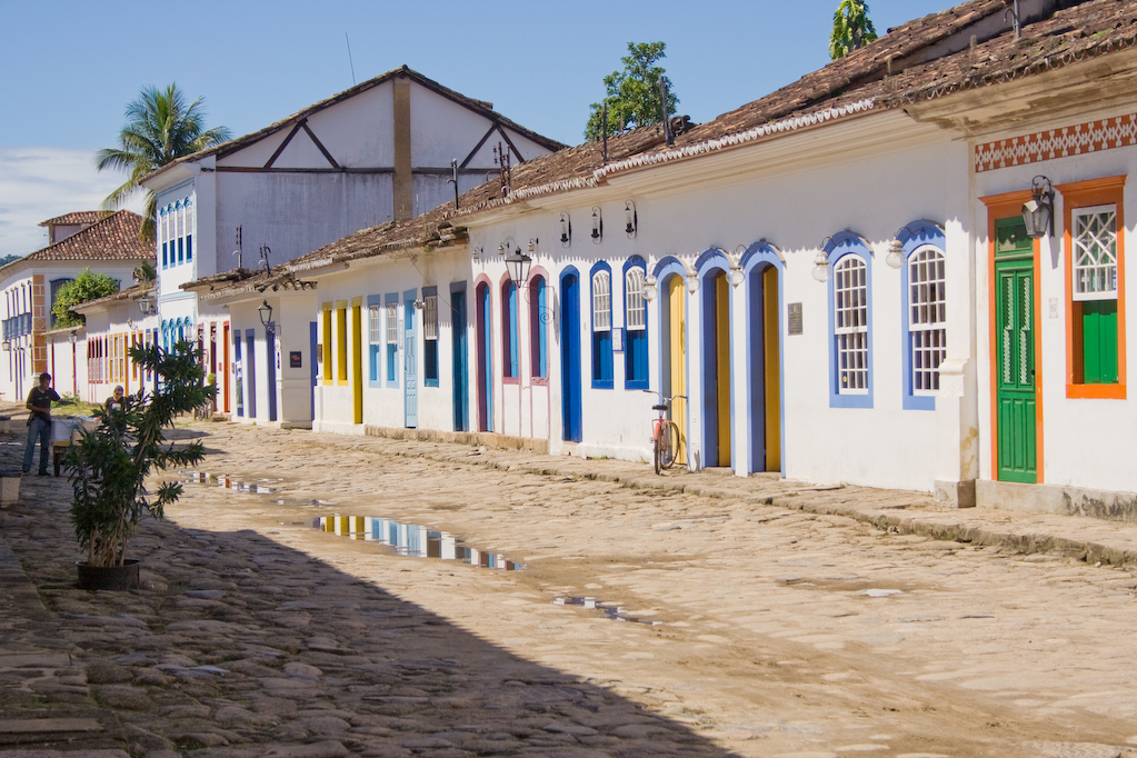 colorful buildings with tiled roofs are seen against a blue sky