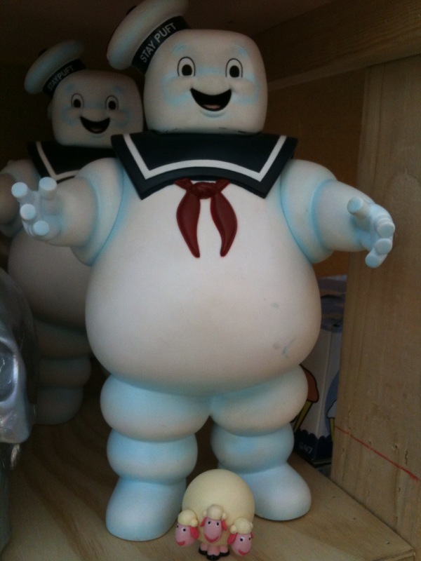 a giant inflatable character poses next to a small toy