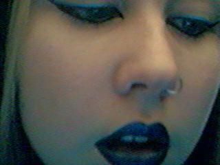 a woman with blue makeup is making a face