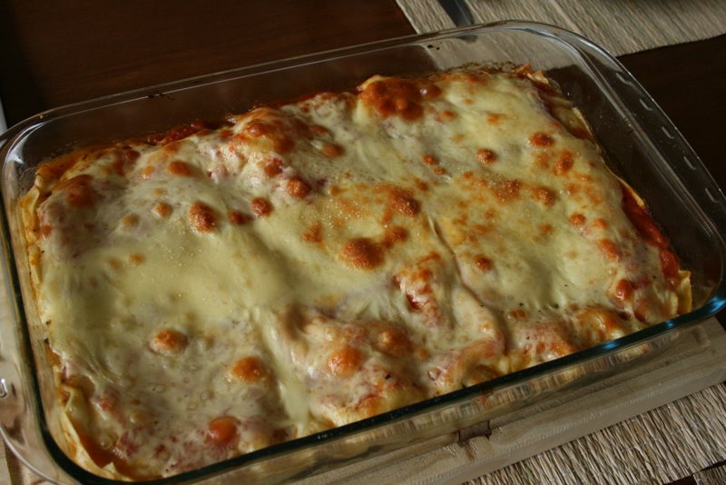 baked dish sitting in glass pan with cheese covering