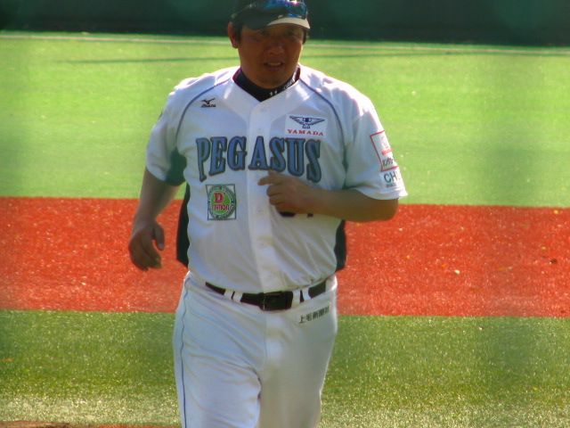 a man in a baseball uniform is holding his hands together