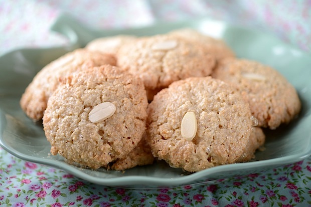 a plate of almond cookies on a table cloth