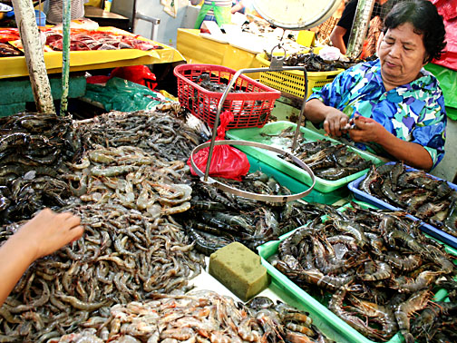 a woman is standing behind a display of seafood