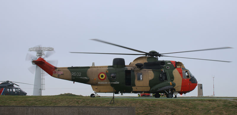 a military helicopter with a water tank on top