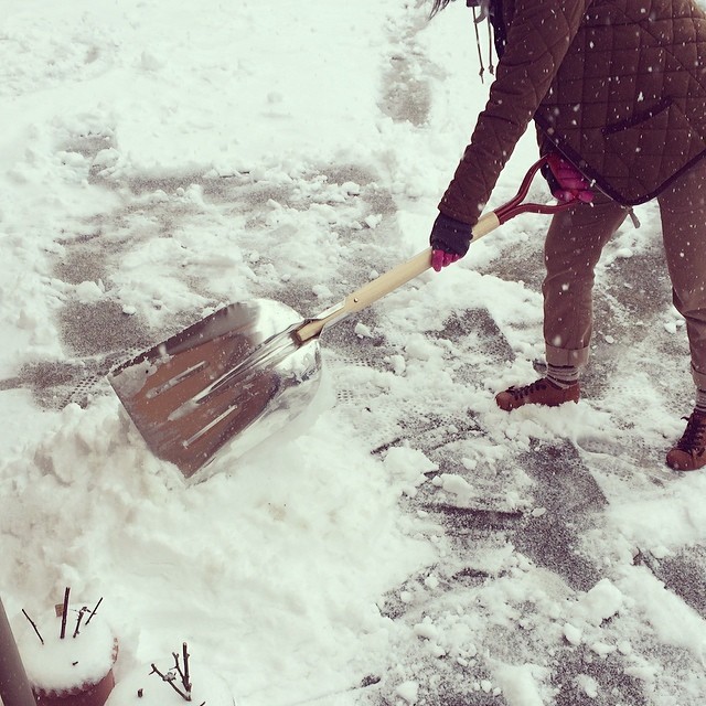 a woman shoveling snow with a shovel