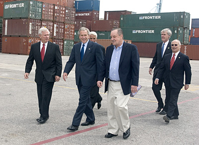 five men in suits and ties walking down the street