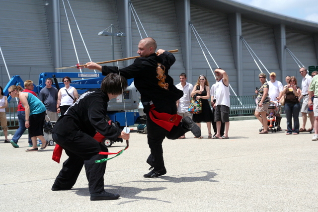 two men performing martial with spectators behind them