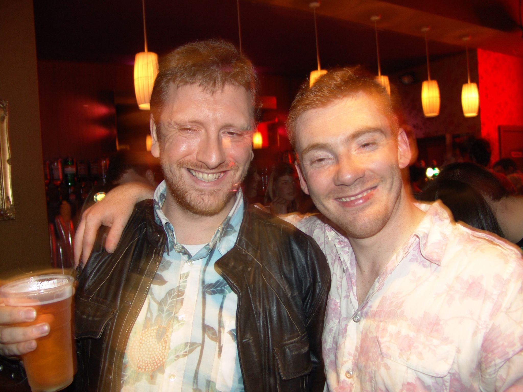 two men pose for a picture together at a party