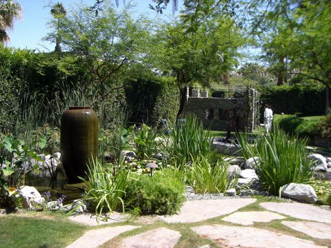 a garden is seen with grass, rocks and bushes
