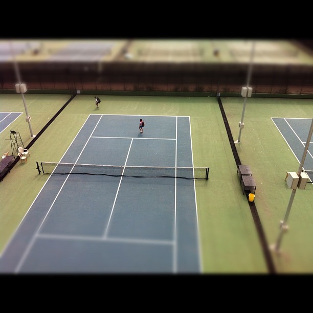 an aerial view of two people playing a tennis game