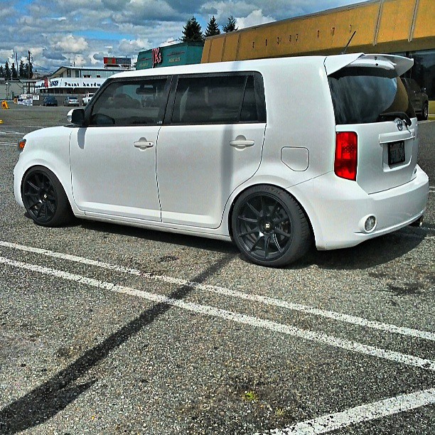 white minivan parked in parking lot near warehouse