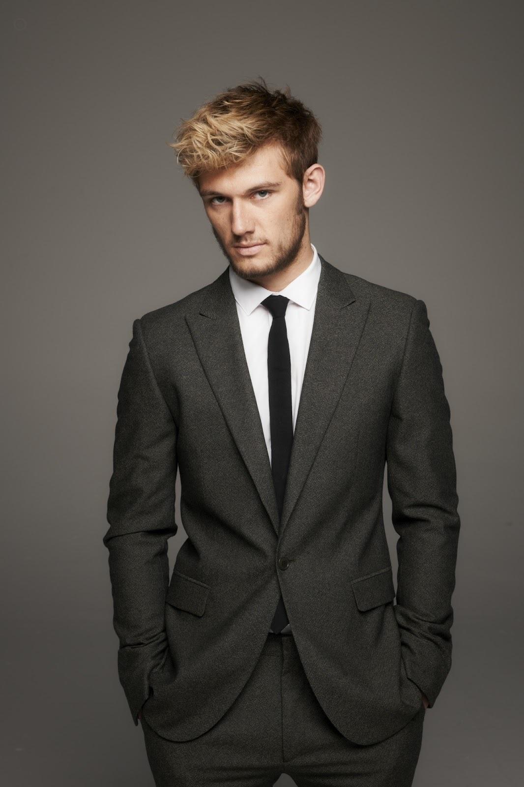 young man in suit and black tie looking at the camera